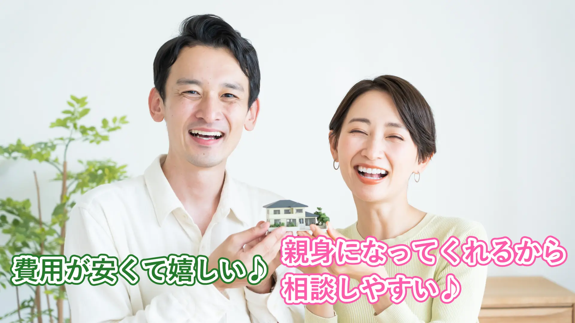 住宅の模型を持つ笑顔の夫婦